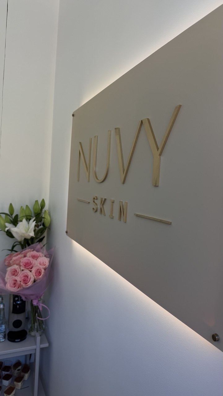 Logo NUVY SKIN na ścianie gabinetu